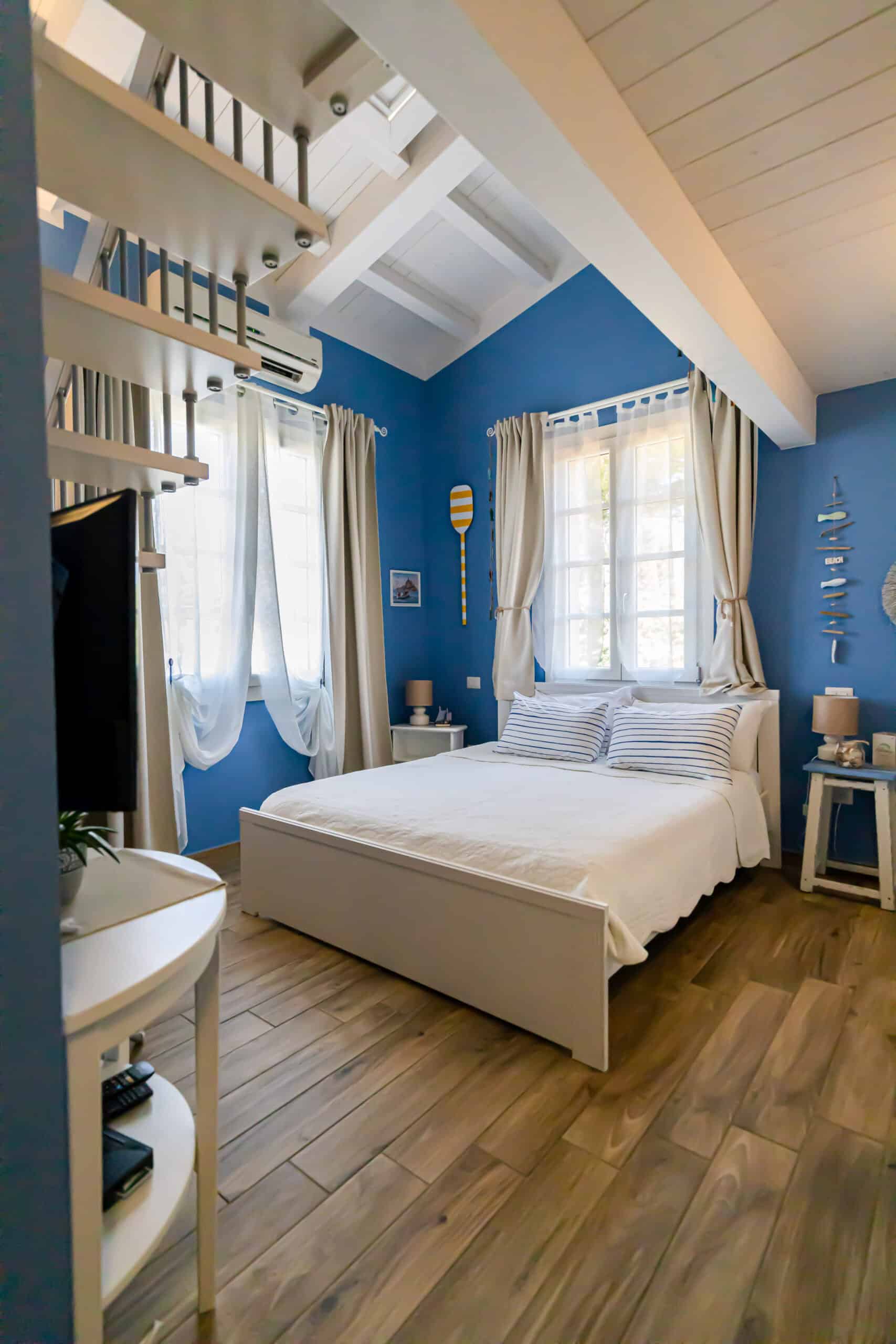 camera con pareti blu e letto matrimoniale